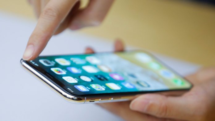 An Apple staff member demonstrates a new iPhone X during a presentation for the media in Beijing